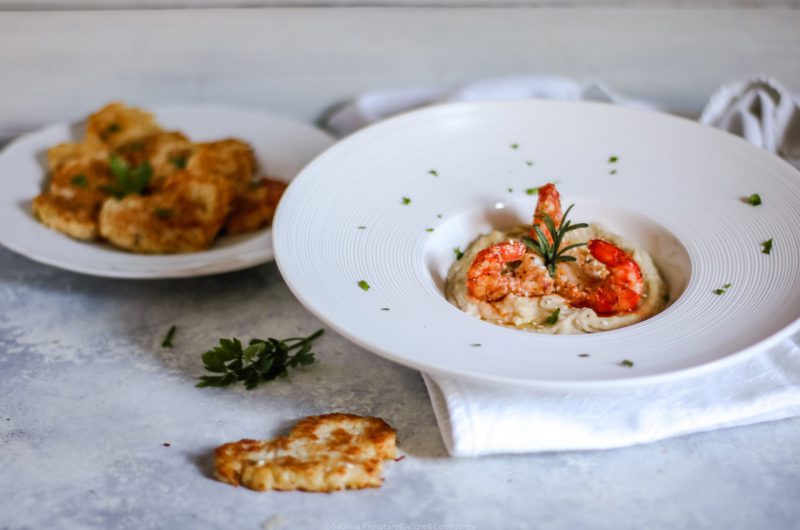 Gamberoni al brandy su purea di cannellini speziati e cuori di patate dorati