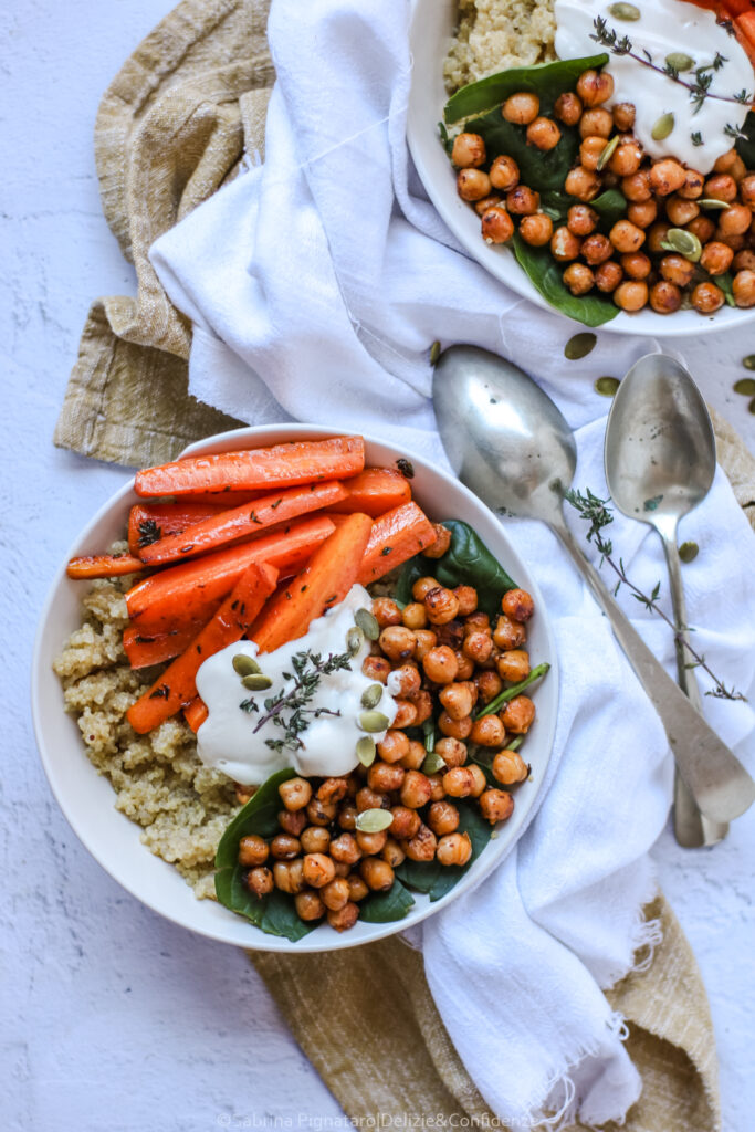 Bowl di quinoa con ceci speziati, carote al timo e salsa cremosa di yogurt vegetale e tahina