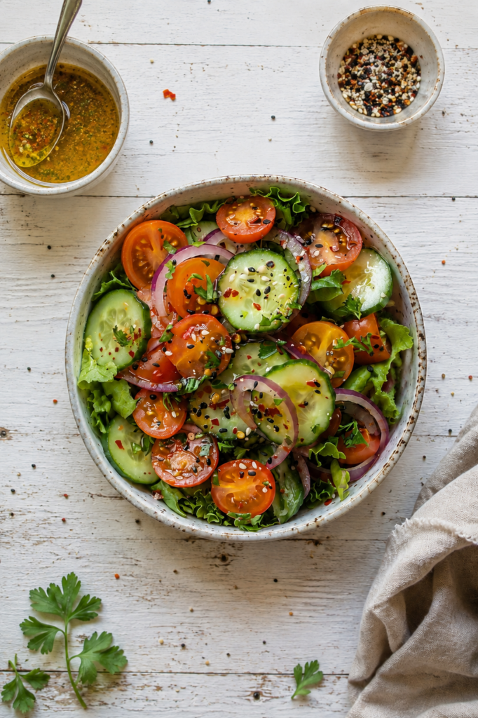 Insalata estiva di pomodori cetrioli cipolla rossa e semi con vinaigrette